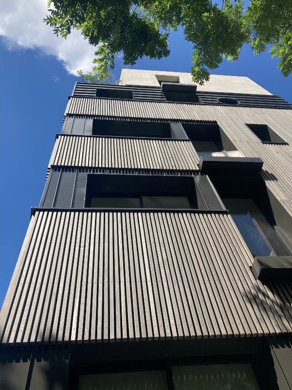 Ein Wohnhaus in Paris mit Fassade aus vorvergrautem Massivholz
