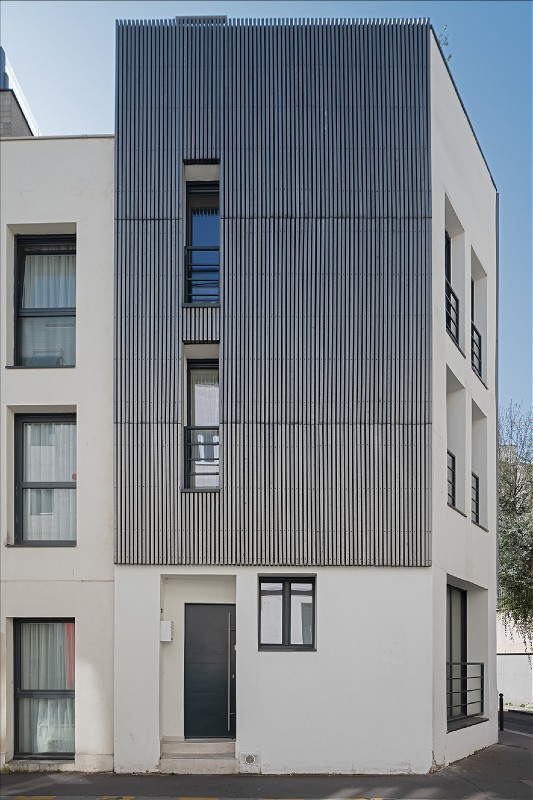 Ein Wohnhaus in Paris mit Fassade aus vorvergrautem Massivholz