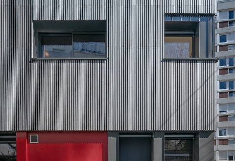 Ein Wohnhaus in Paris mit Fassade aus vorvergrautem Massivholz