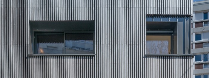 Ein Wohnhaus in Paris mit Fassade aus vorvergrautem Massivholz